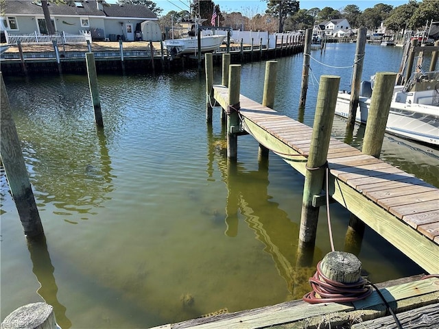 view of dock with a residential view and a water view