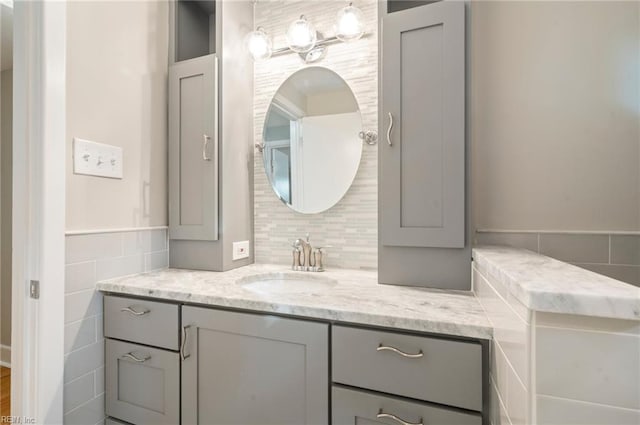 bathroom featuring backsplash, vanity, and tile walls