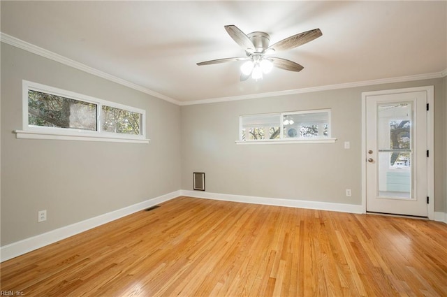 unfurnished room featuring light wood finished floors, crown molding, and baseboards