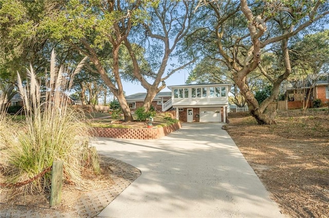 view of front of property featuring brick siding, driveway, and an attached garage