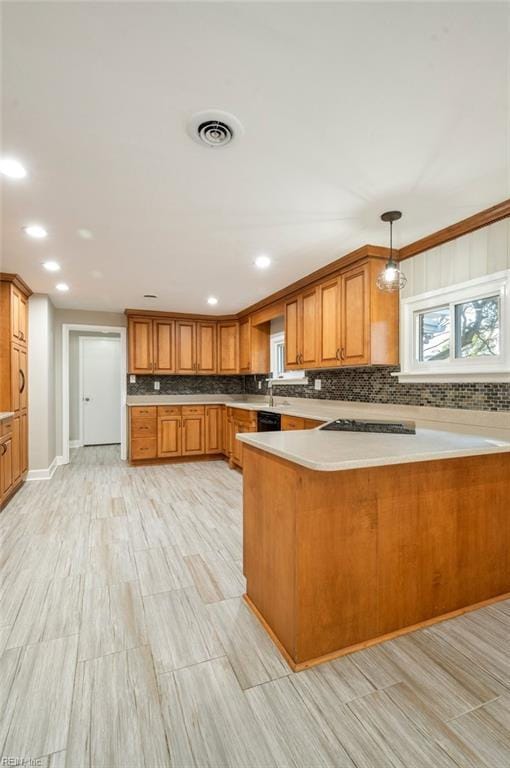 kitchen with brown cabinetry, visible vents, cooktop, and a peninsula