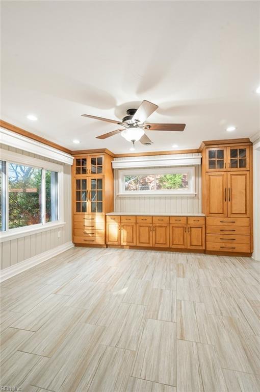 unfurnished living room with recessed lighting, ornamental molding, and a ceiling fan