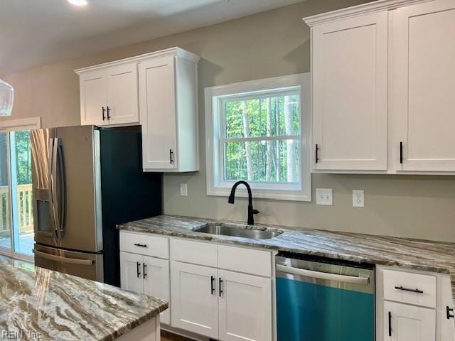 kitchen featuring white cabinets, dishwasher, stainless steel fridge with ice dispenser, and a sink