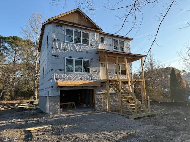 exterior space with stairs, an attached garage, covered porch, and driveway