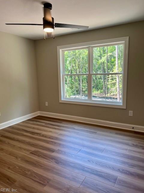 unfurnished room featuring ceiling fan, baseboards, and wood finished floors