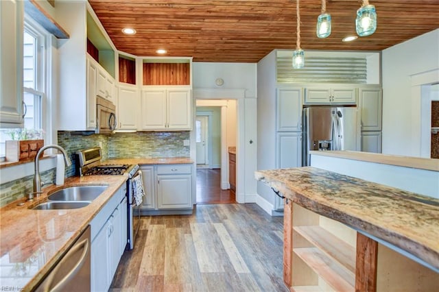 kitchen featuring light wood finished floors, a sink, decorative backsplash, wood ceiling, and appliances with stainless steel finishes