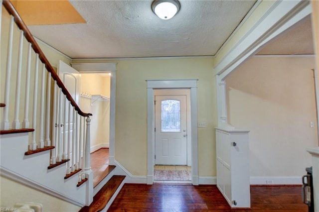 entryway featuring stairway, baseboards, wood-type flooring, and a textured ceiling