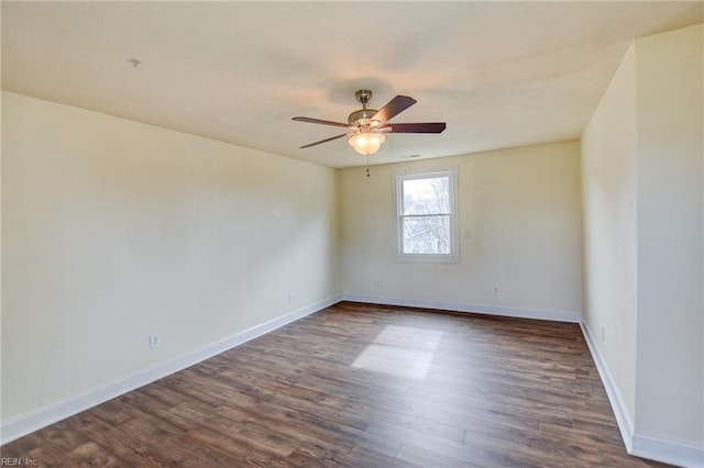 empty room with baseboards, dark wood finished floors, and a ceiling fan