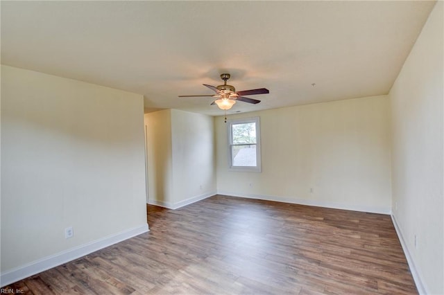 empty room with ceiling fan, baseboards, and wood finished floors