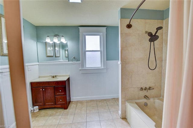 full bath with vanity, tile patterned floors, shower / bath combo, and a wainscoted wall