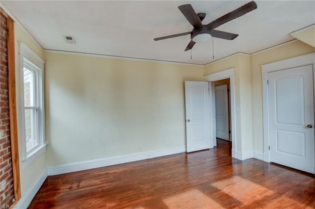 unfurnished bedroom featuring visible vents, ornamental molding, wood finished floors, baseboards, and ceiling fan