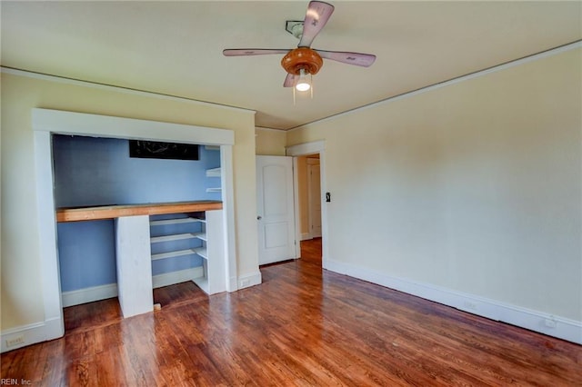 unfurnished room featuring baseboards, a ceiling fan, and wood finished floors