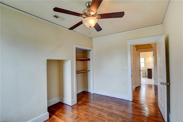 unfurnished bedroom with visible vents, baseboards, a closet, and wood finished floors