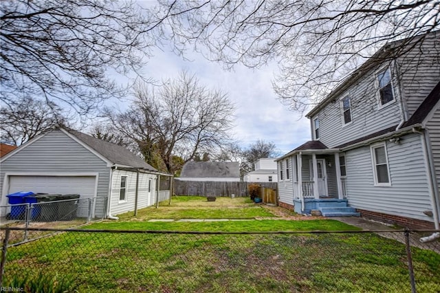 view of yard featuring an outbuilding, a garage, and a fenced backyard