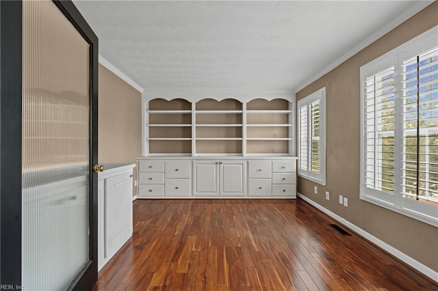 interior space featuring visible vents, crown molding, baseboards, built in features, and dark wood-style floors