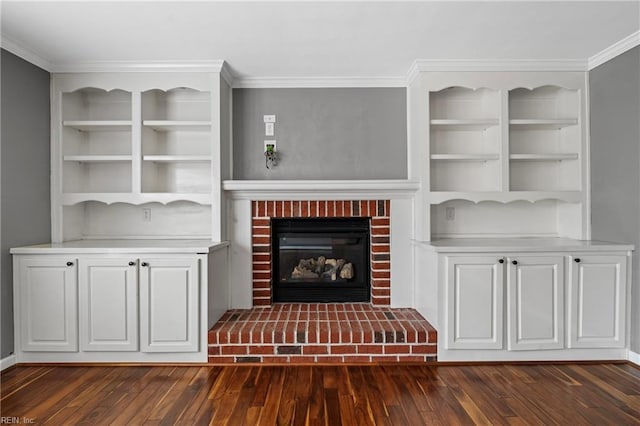 unfurnished living room featuring a brick fireplace, dark wood finished floors, and ornamental molding