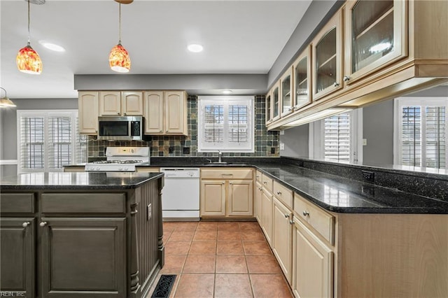 kitchen featuring visible vents, glass insert cabinets, light tile patterned floors, decorative backsplash, and white appliances