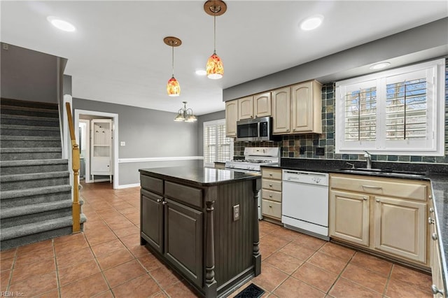 kitchen with backsplash, light brown cabinets, a center island, white appliances, and a sink