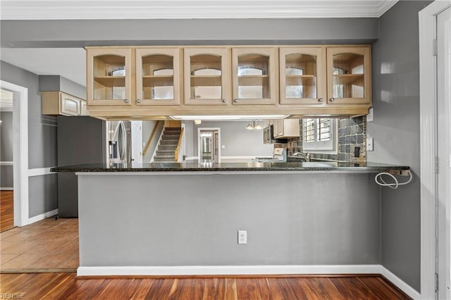 kitchen featuring tasteful backsplash, stove, glass insert cabinets, and baseboards