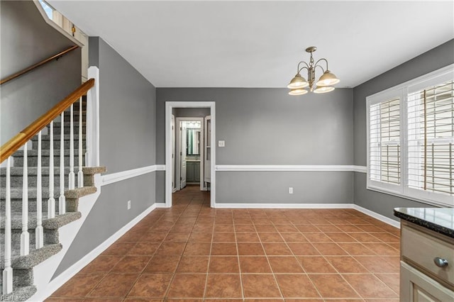 empty room featuring baseboards, a chandelier, stairs, and tile patterned flooring