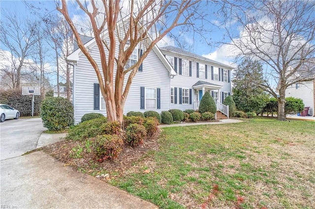 colonial-style house featuring a front yard