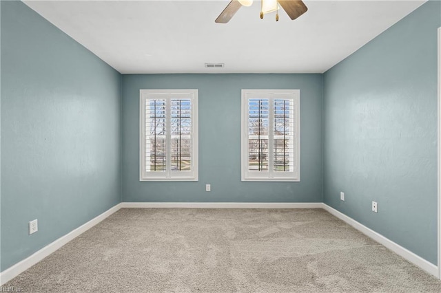 carpeted spare room featuring visible vents, plenty of natural light, and baseboards