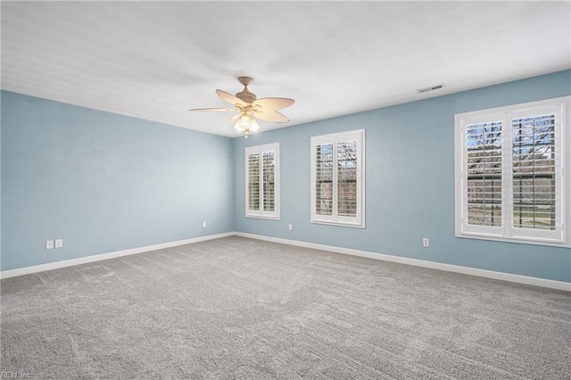 carpeted empty room featuring visible vents, baseboards, and ceiling fan