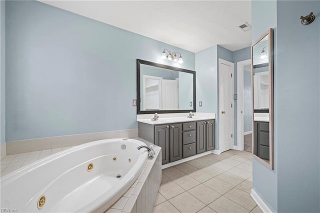 bathroom featuring visible vents, double vanity, tile patterned floors, a tub with jets, and a sink