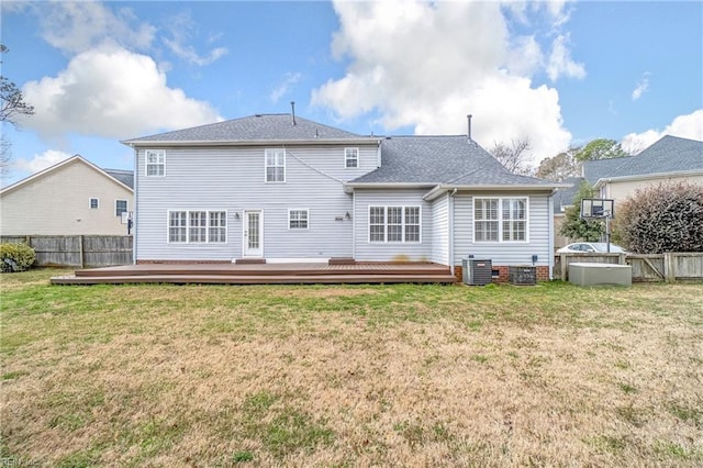 back of house featuring a lawn, central AC, a deck, and fence