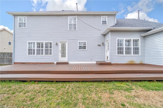 back of property featuring a deck and a yard