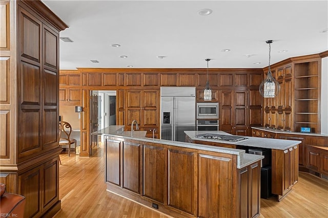 kitchen featuring built in appliances, wood walls, an island with sink, light wood-style floors, and open shelves