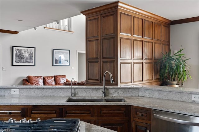 kitchen with light stone counters, appliances with stainless steel finishes, and a sink