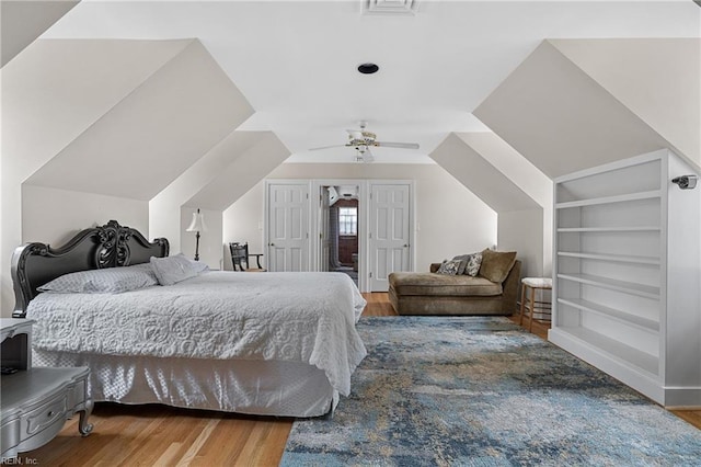 bedroom featuring ceiling fan, wood finished floors, and vaulted ceiling