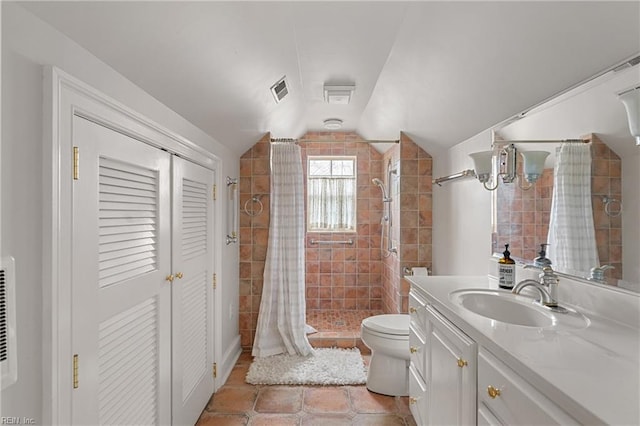 bathroom featuring vanity, lofted ceiling, a stall shower, tile patterned flooring, and toilet