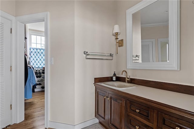 bathroom featuring baseboards, wood finished floors, and vanity