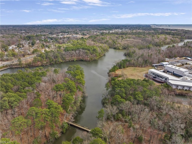 drone / aerial view with a forest view and a water view