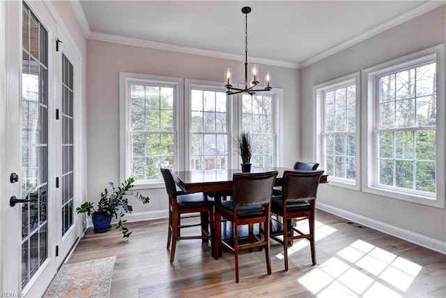 dining area featuring an inviting chandelier, wood finished floors, and crown molding