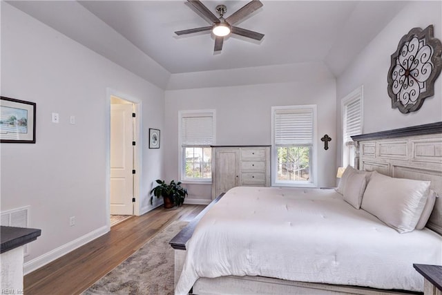 bedroom with a ceiling fan, baseboards, and wood finished floors