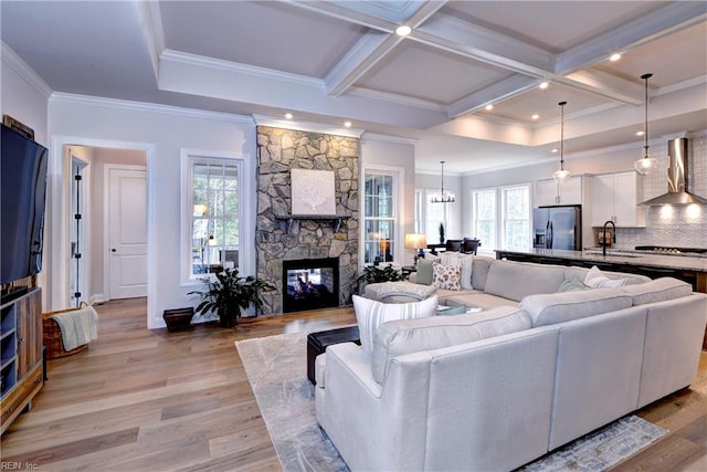 living room featuring beam ceiling, light wood-style flooring, coffered ceiling, and a fireplace