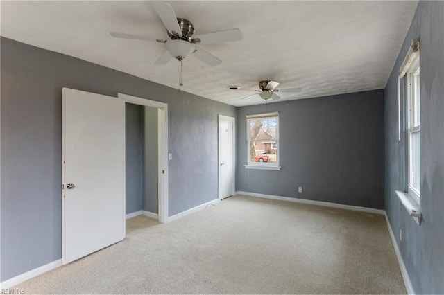 spare room with light carpet, baseboards, and a ceiling fan