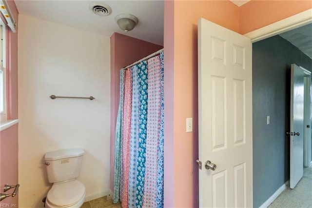 full bathroom featuring visible vents, toilet, a shower with shower curtain, and baseboards