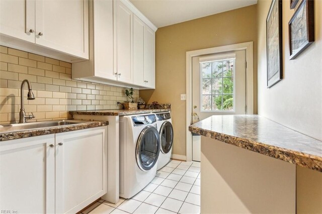 clothes washing area with washer and clothes dryer, light tile patterned floors, cabinet space, and a sink