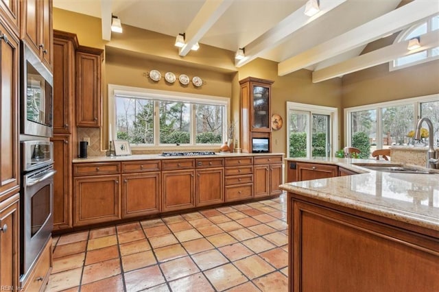 kitchen with brown cabinets, appliances with stainless steel finishes, and a sink