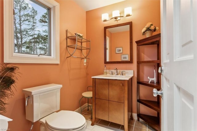 half bath featuring tile patterned flooring, toilet, vanity, and baseboards