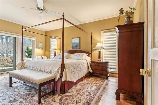 bedroom featuring access to exterior, a ceiling fan, light wood finished floors, and ornamental molding