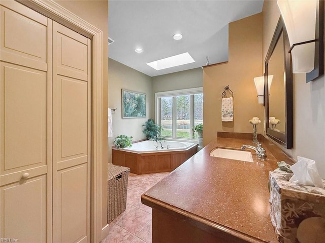 full bath featuring vanity, a garden tub, a skylight, recessed lighting, and tile patterned floors