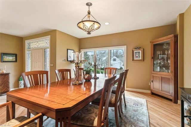 dining room with baseboards and light wood-type flooring