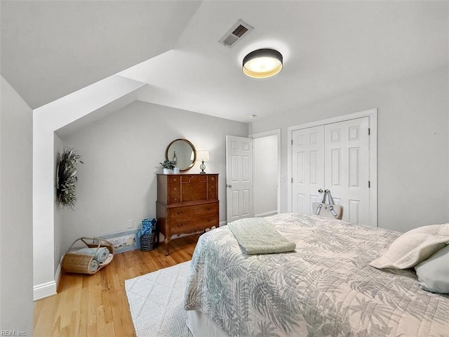 bedroom featuring visible vents, baseboards, a closet, and wood finished floors