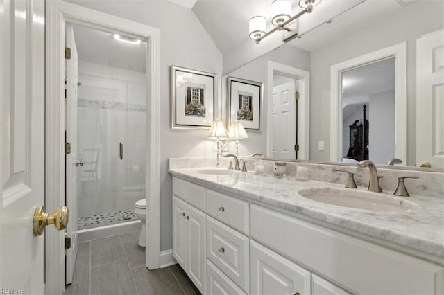 bathroom with a sink, toilet, double vanity, and a shower stall