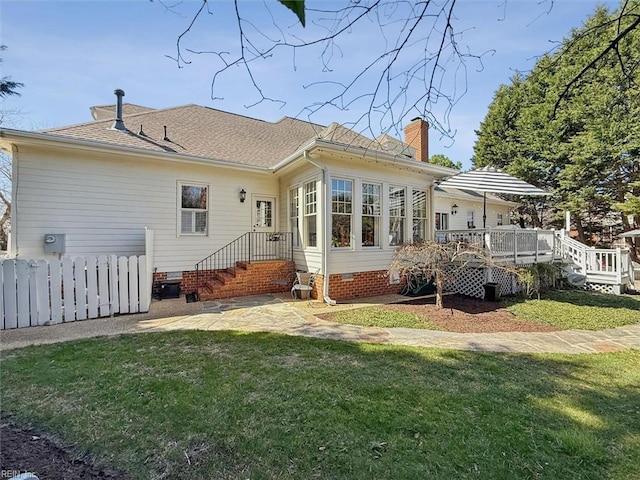 rear view of property with crawl space, a lawn, a chimney, and roof with shingles